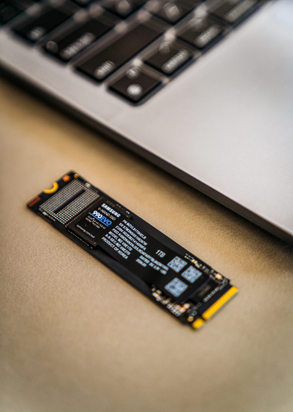 En SSD-disk som ligger bredvid ett laptoptangentbord